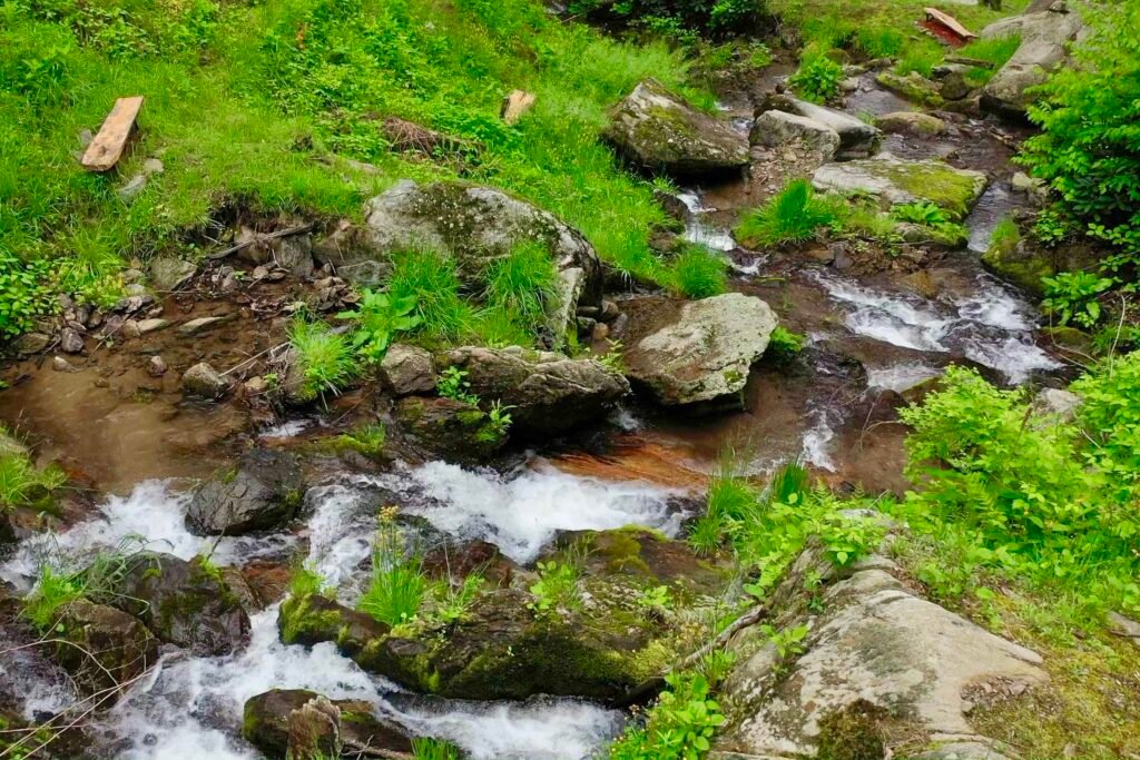 drone cascades from flat rock Natural mountain waterfall beside the Windows Over Waterfalls cabin, cascading over rocks in a quiet forest setting in western North Carolina.