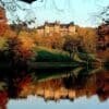 Asheville fall foliage — Biltmore Estate surrounded by crimson and gold fall color in October with the Blue Ridge Mountains in the background