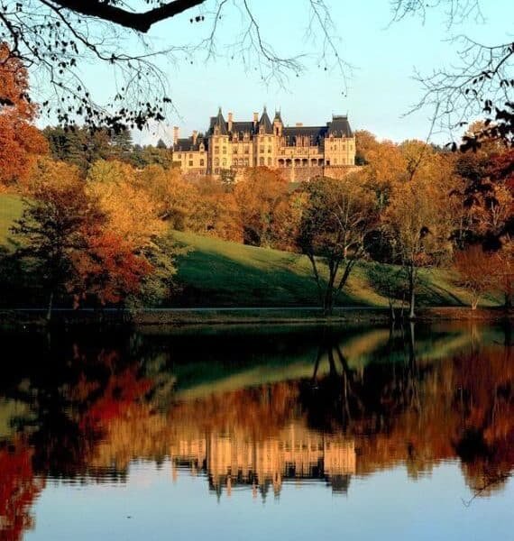 Asheville fall foliage — Biltmore Estate surrounded by crimson and gold fall color in October with the Blue Ridge Mountains in the background