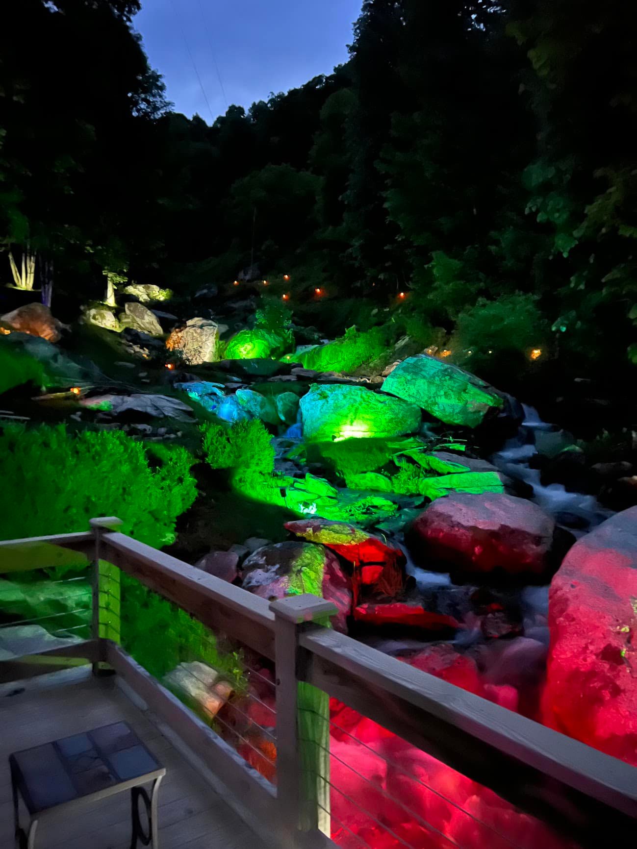 Waterfalls lit up at night from patio at Windows Over Waterfalls