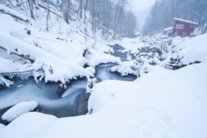 Snow-covered cabin above the falls at Windows Over Waterfalls in winter